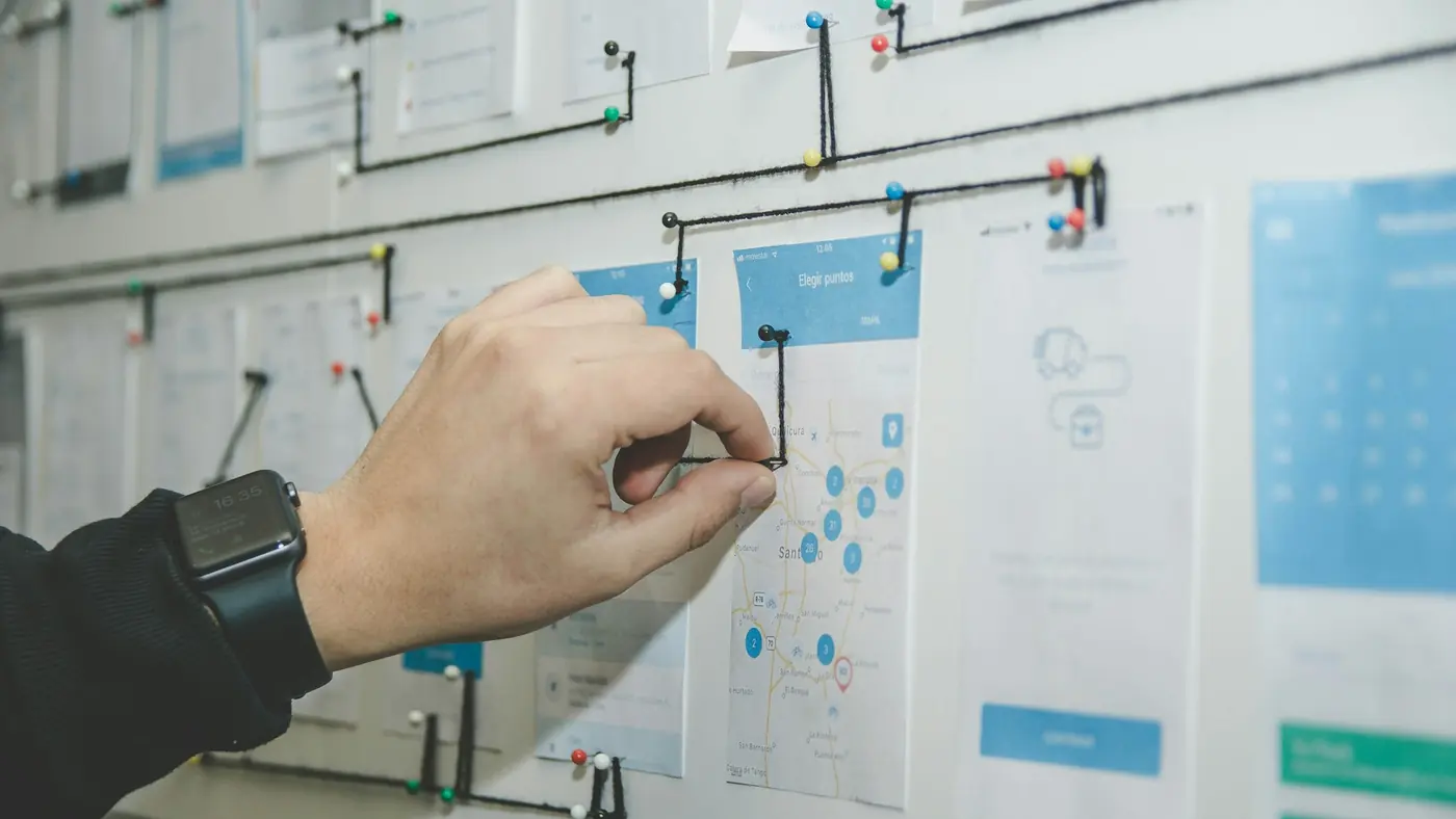 A hand moving task cards on a board divided into columns