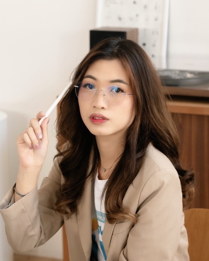 Tarn Wuttiporn, product designer, holding a stylus in a bright studio